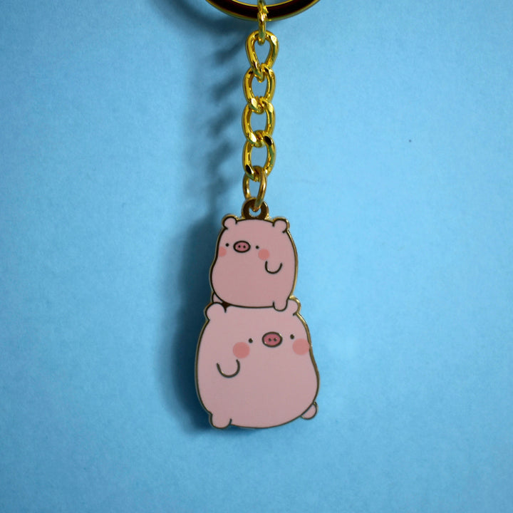 Pig keyring with gold chain on blue background