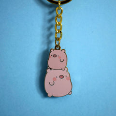 Pig keyring with gold chain on blue background
