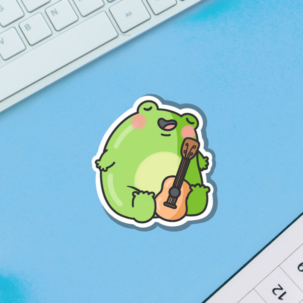 Frog playing guitar vinyl sticker on blue background 