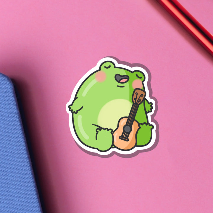 Frog playing guitar vinyl sticker on blue and purple background