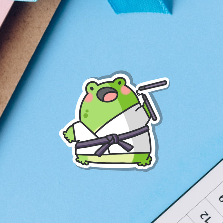 Karate frog vinyl sticker on blue table