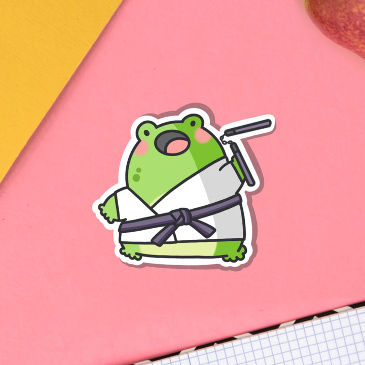 Karate frog vinyl sticker on pink table