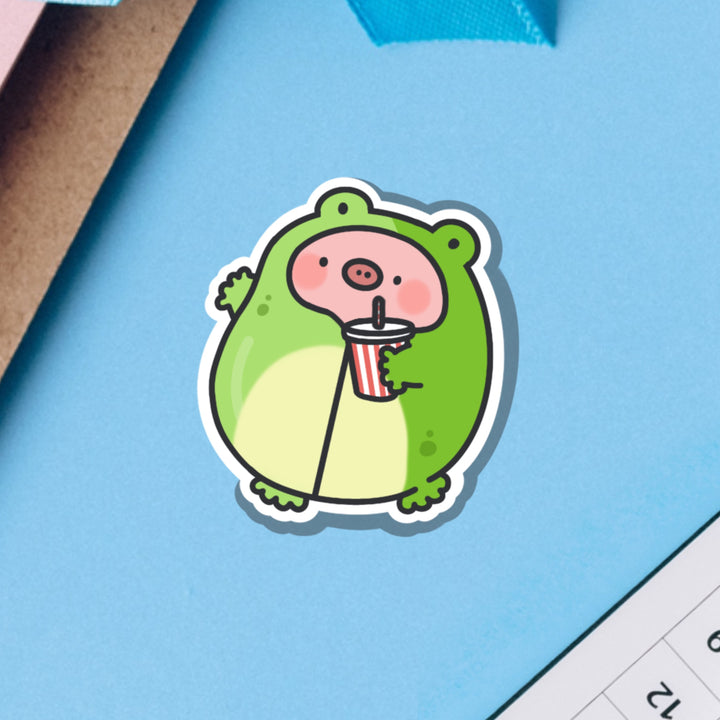 Pig in Frog Outfit Vinyl sticker on blue table