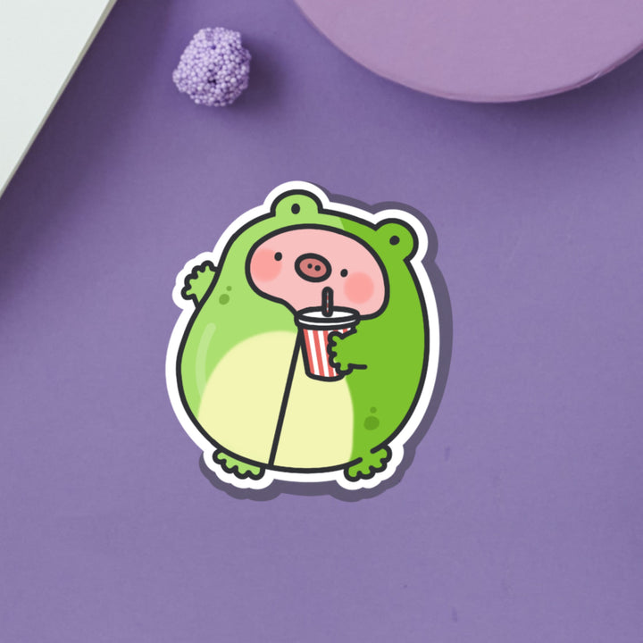 Pig in Frog Outfit Vinyl sticker on purple table