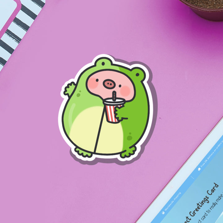 Pig in Frog Outfit Vinyl sticker on purple table and ipad