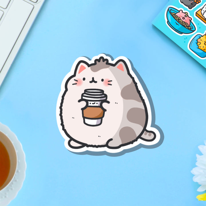 Cat holding coffee vinyl sticker on blue background