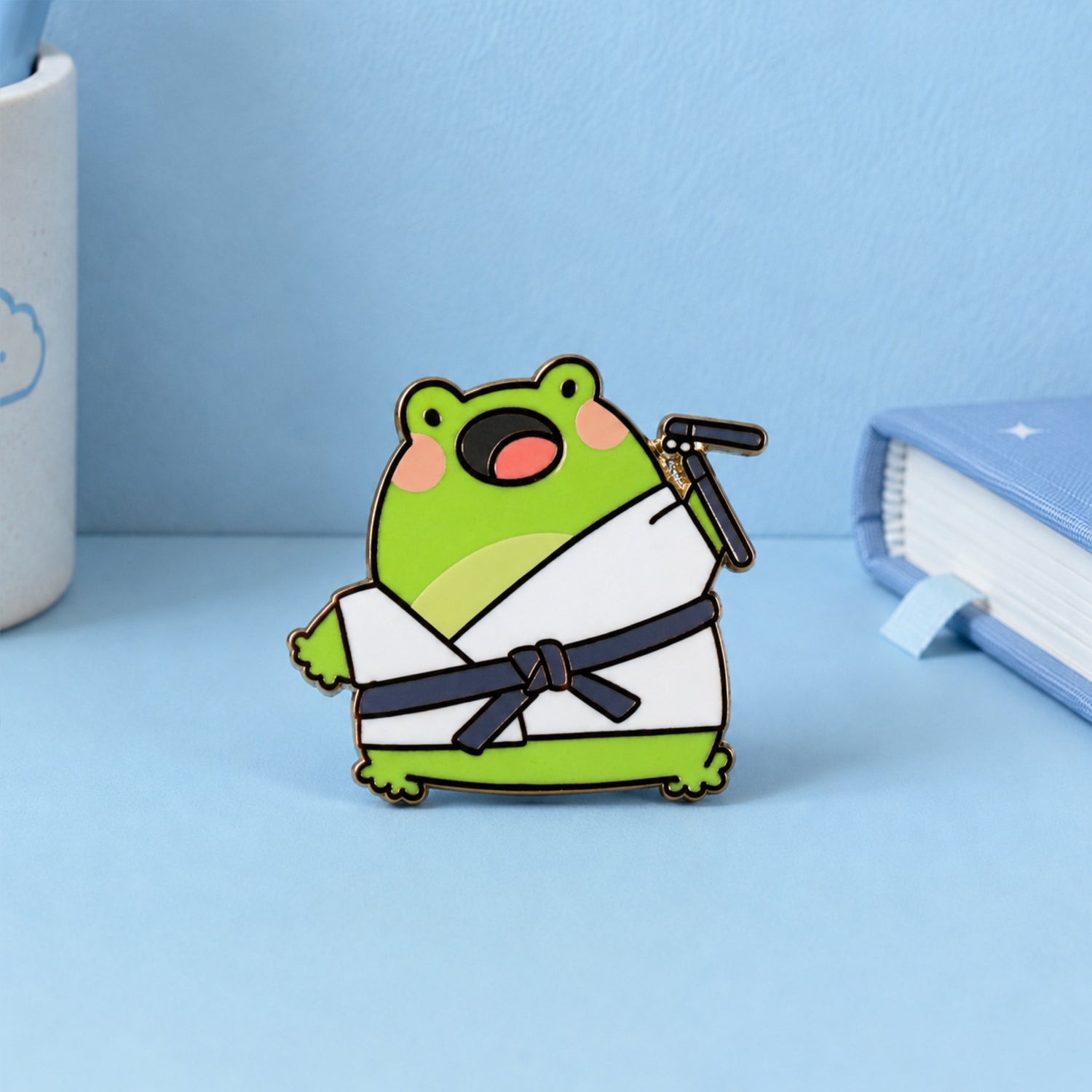 Karate frog enamel pin with blue notebook and pen holder