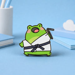 Karate frog enamel pin on blue desk