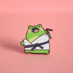 Karate frog enamel pin on pink table