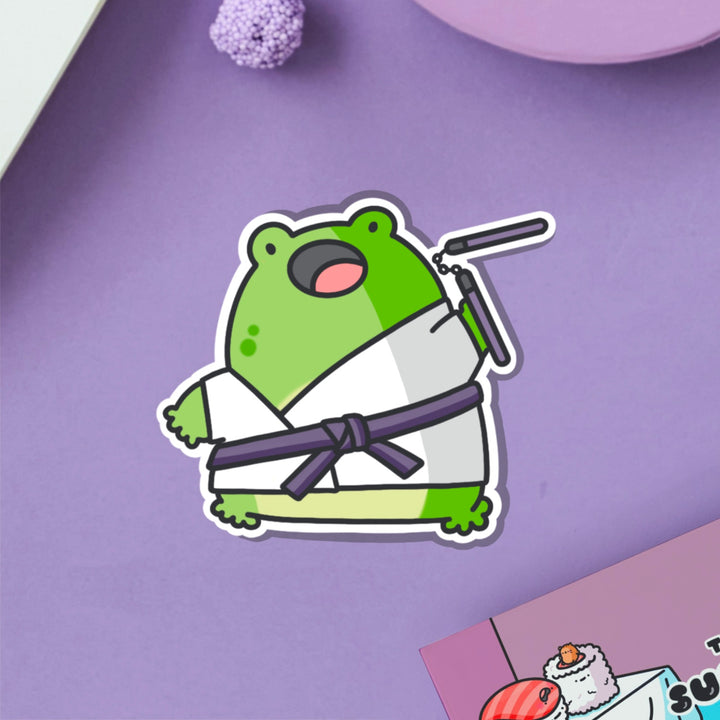 Karate frog vinyl sticker on purple table