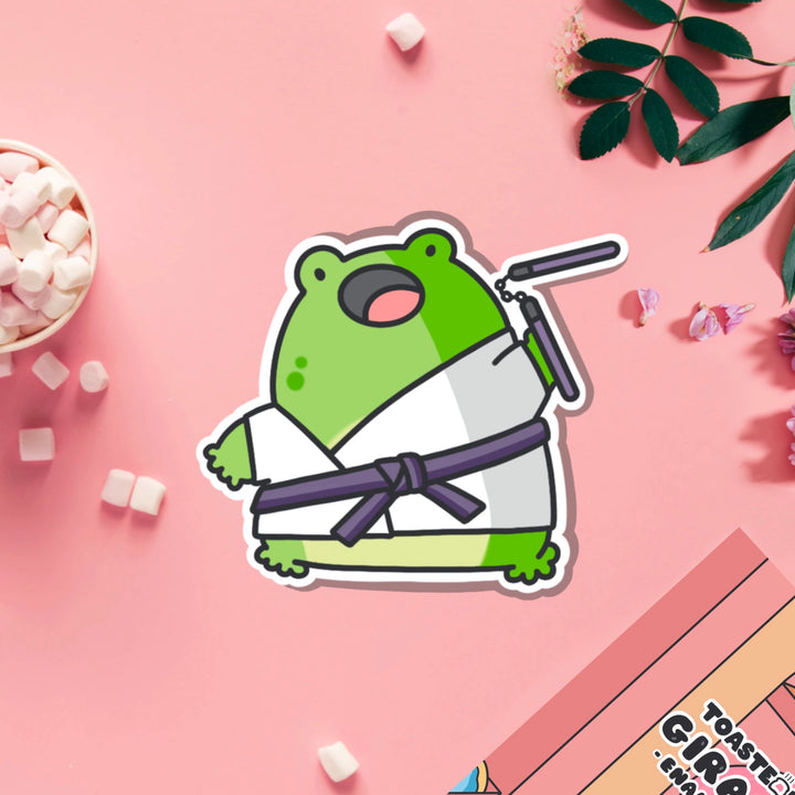 Karate frog vinyl sticker on pink table