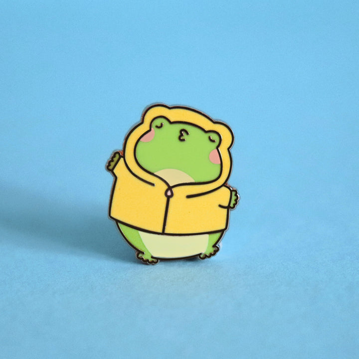 Kissing frog enamel pin on blue background