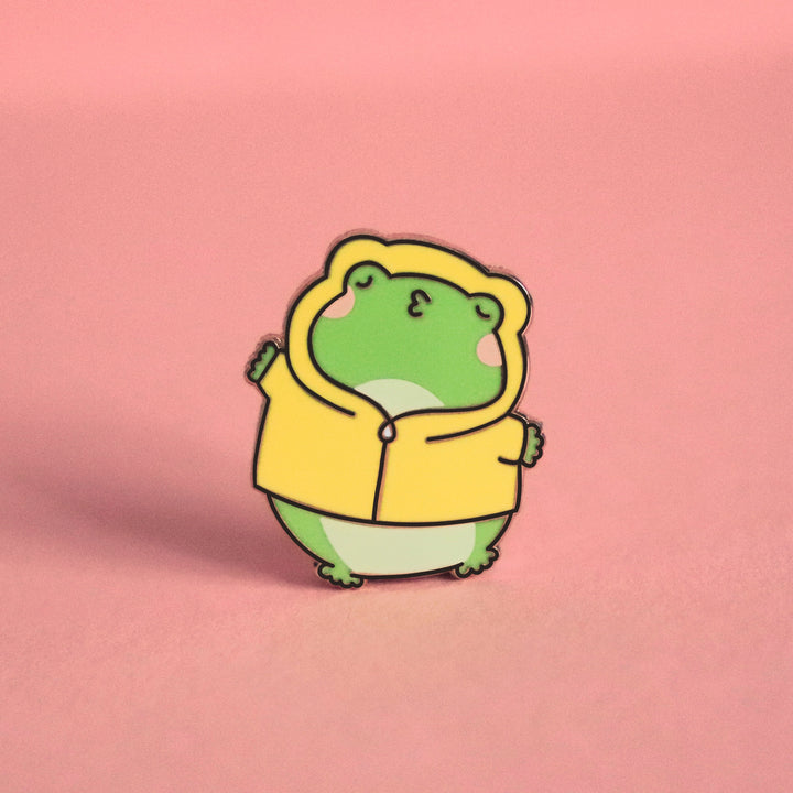 Kissing frog enamel pin on pink background