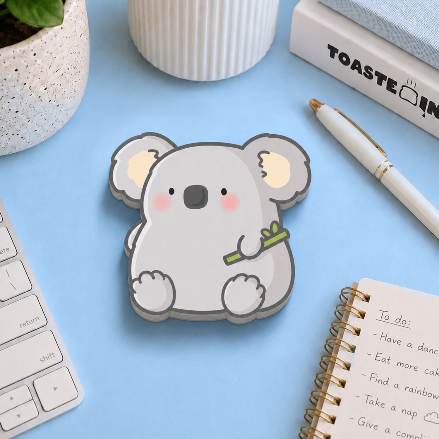 Koala shaped sticky notes on blue table with stationery