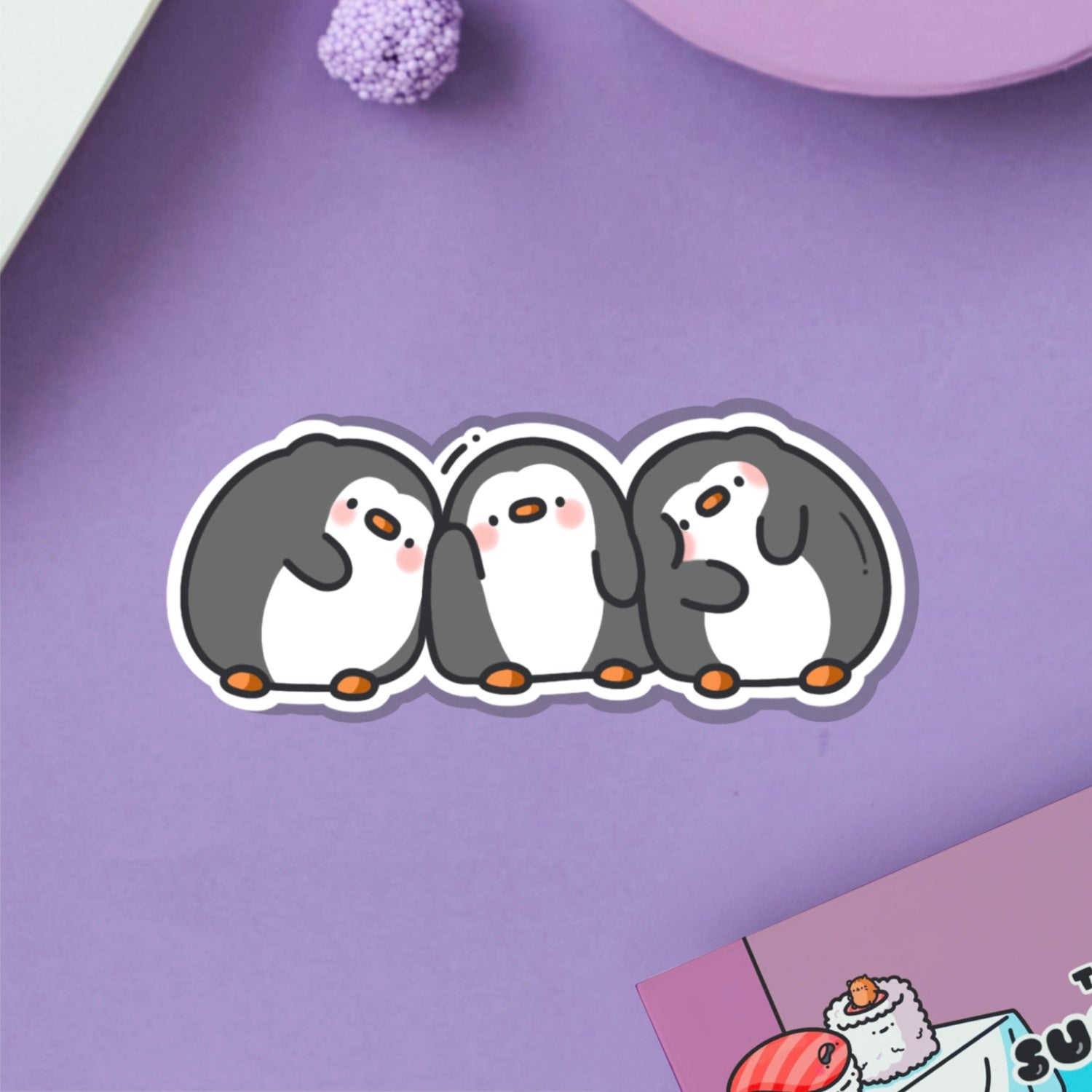 Line of penguins vinyl sticker on purple table