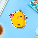 Chick holding love heart vinyl sticker on blue table