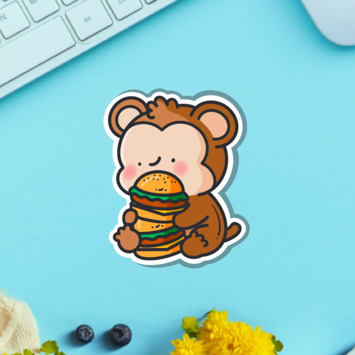 Monkey eating burgers vinyl sticker on green table