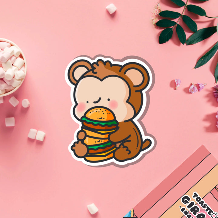 Monkey eating burgers vinyl sticker on pink table