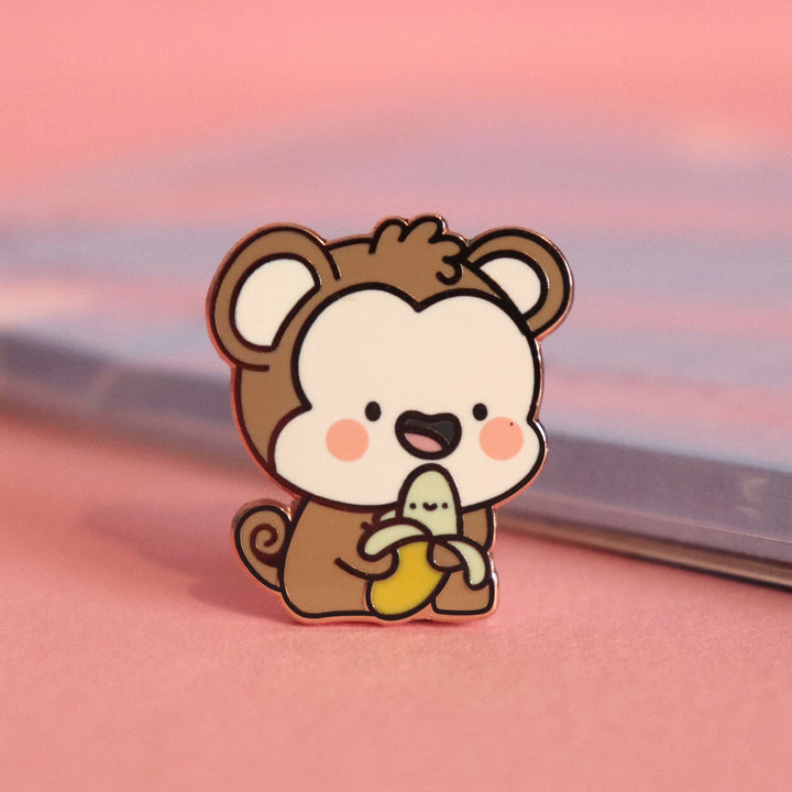 Monkey enamel pin on pink desk