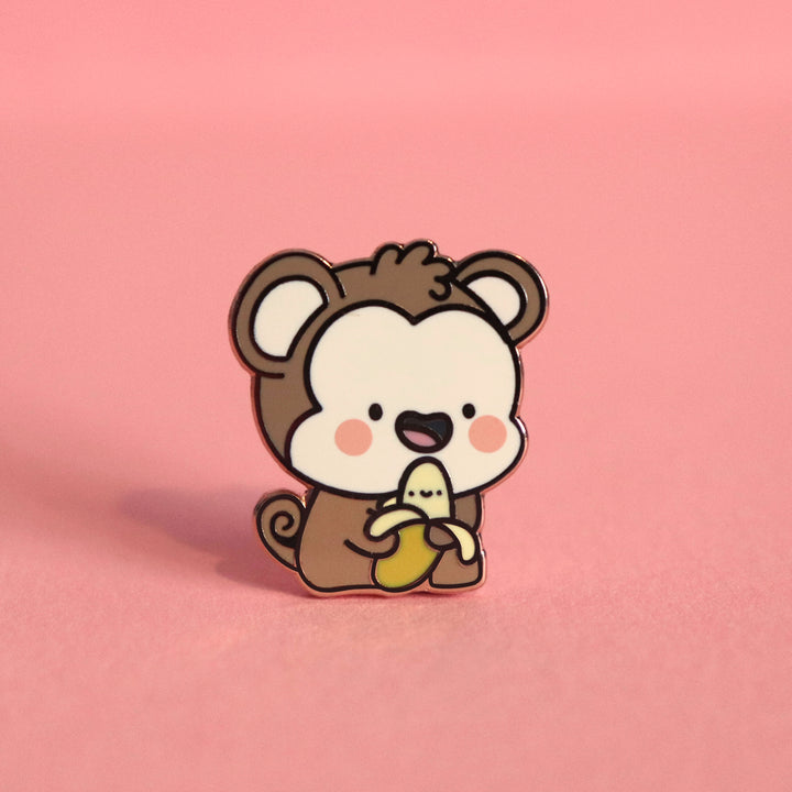 Monkey enamel pin on pink table