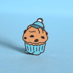 Muffin enamel pin on blue desk