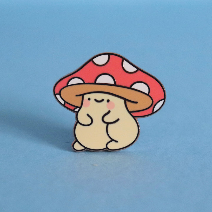 Mushroom enamel pin on blue desk