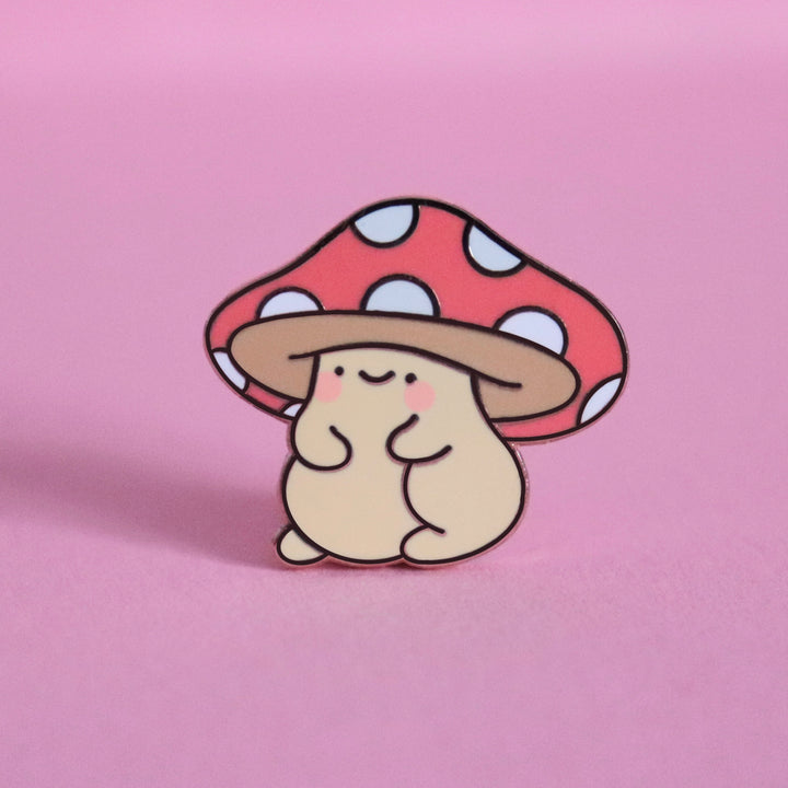 Mushroom enamel pin on pink desk