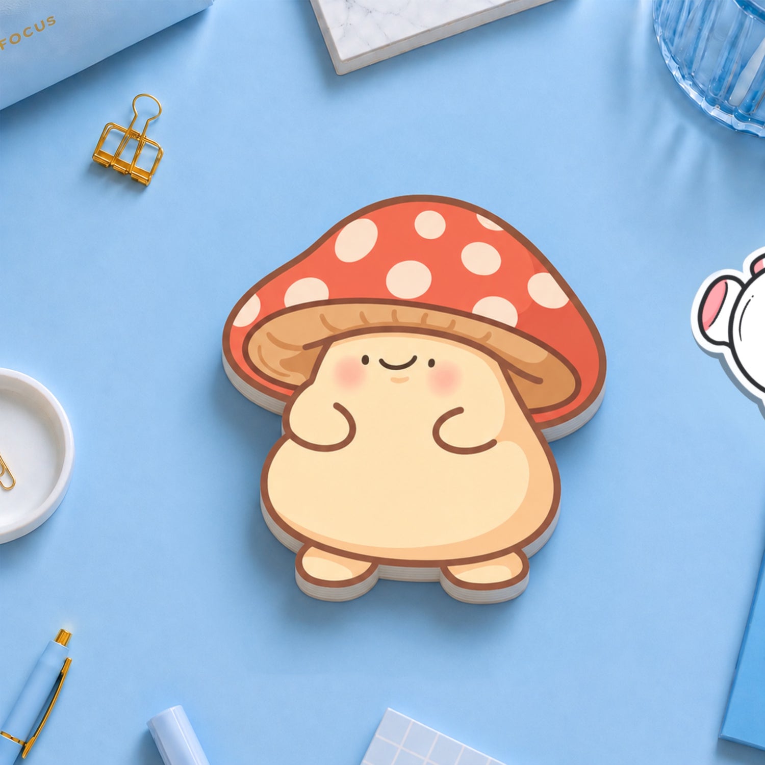 Mushroom sticky notes on blue table with stationery pieces