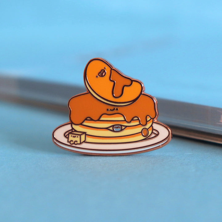 Pancakes enamel pin on blue table with notepad