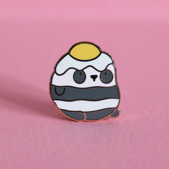 Panda with an egg on his head enamel pin on pink desk