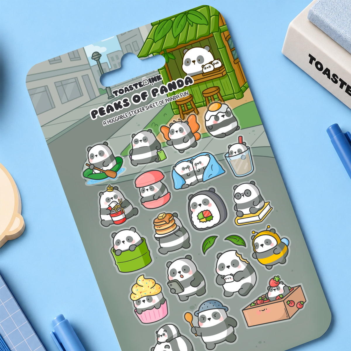 Panda sticker sheet on blue desk with stationery scattered around