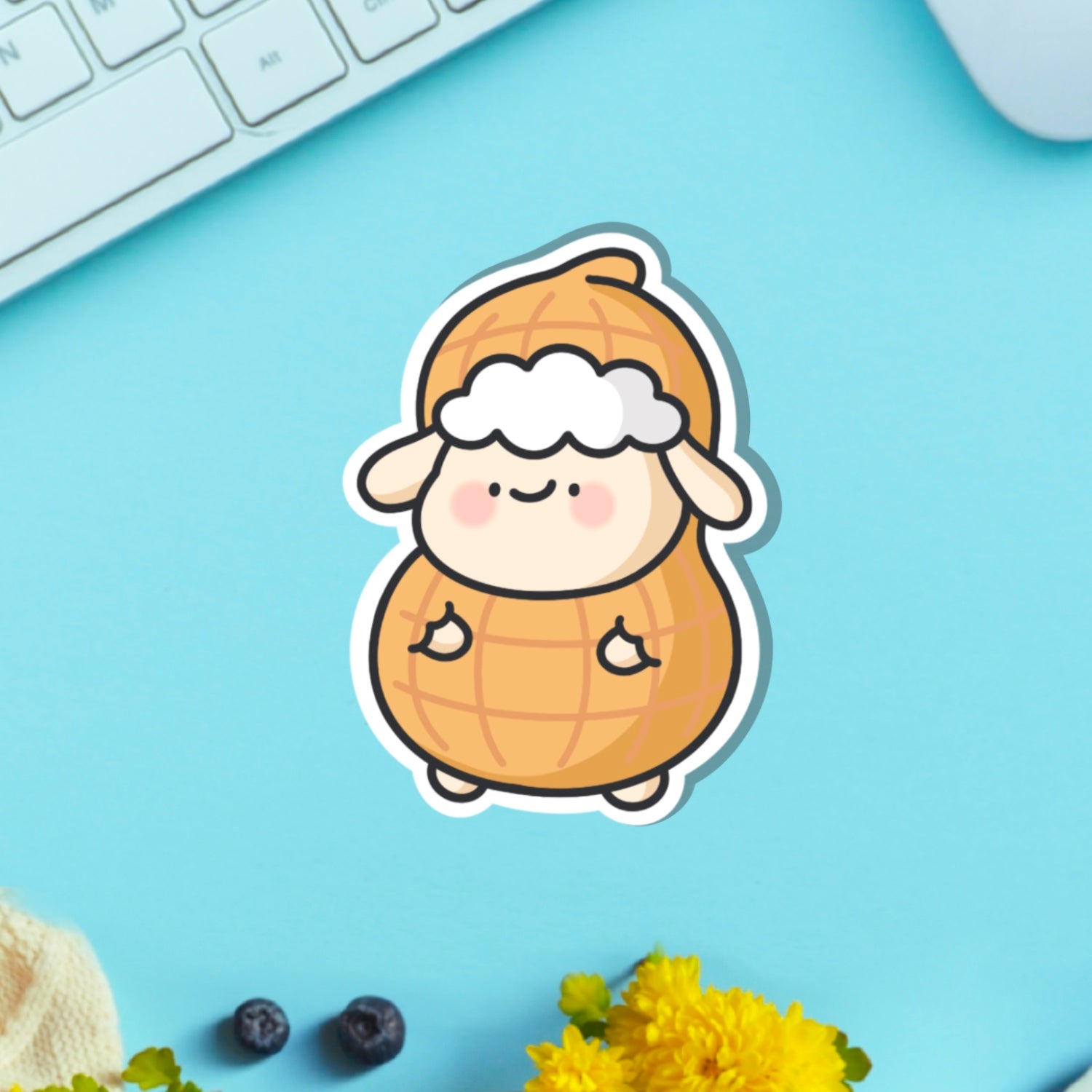 Sheep dressed as peanut vinyl sticker with key board on blue table