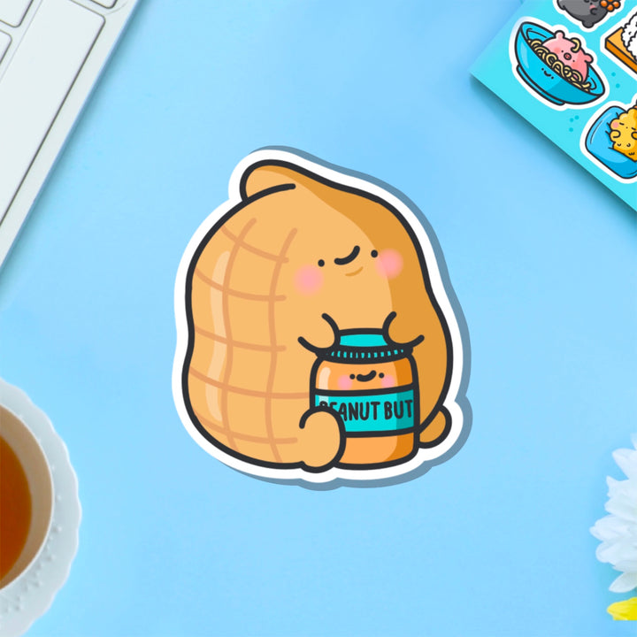 Peanut holding peanut butter vinyl sticker on blue table