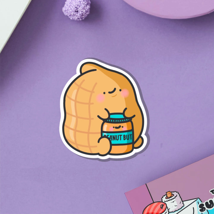 Peanut holding peanut butter vinyl sticker on purple table