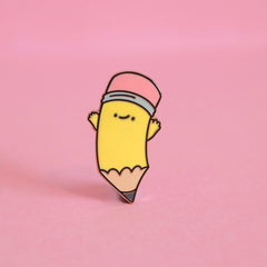 Pencil enamel pin on pink desk