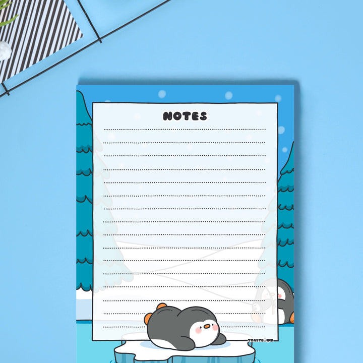 A6 Penguin Notepad on blue desk close up