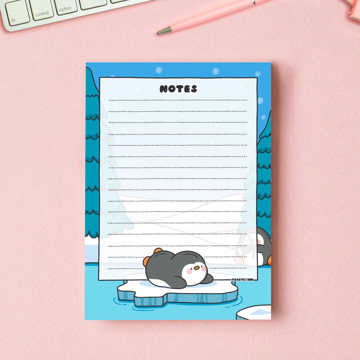 A6 Penguin Notepad on pink table with keyboard