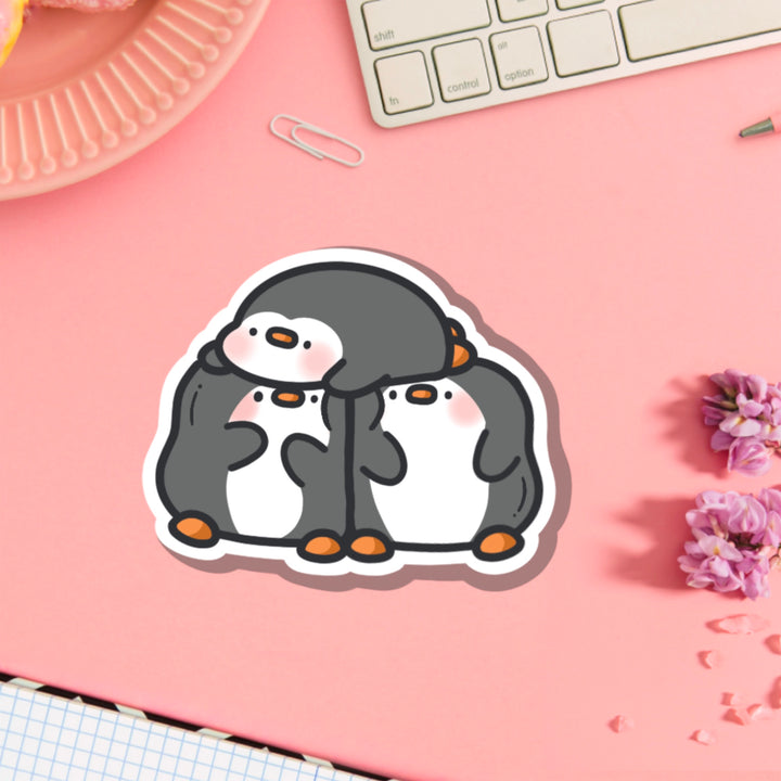 Three penguins vinyl sticker on pink table