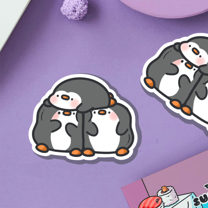 Three penguins vinyl sticker on purple table