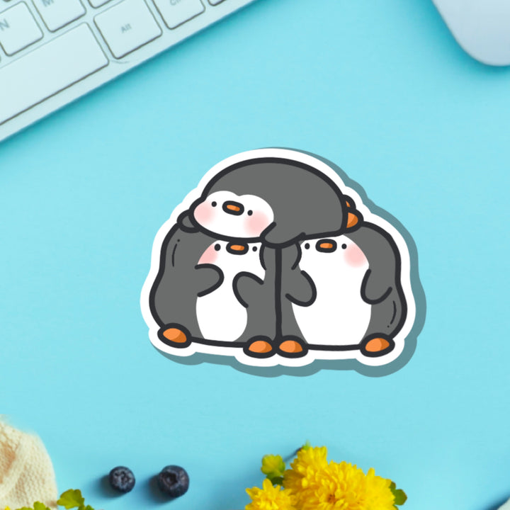 Three penguins vinyl sticker on blue background with keyboard