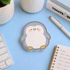 Penguin shaped sticky notes on blue table
