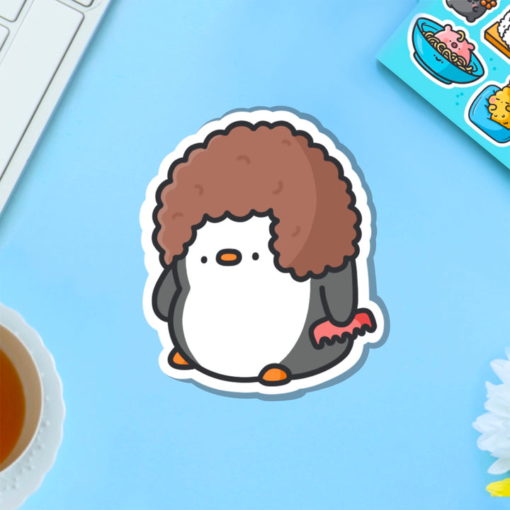 Penguin with hairdo vinyl sticker on blue table