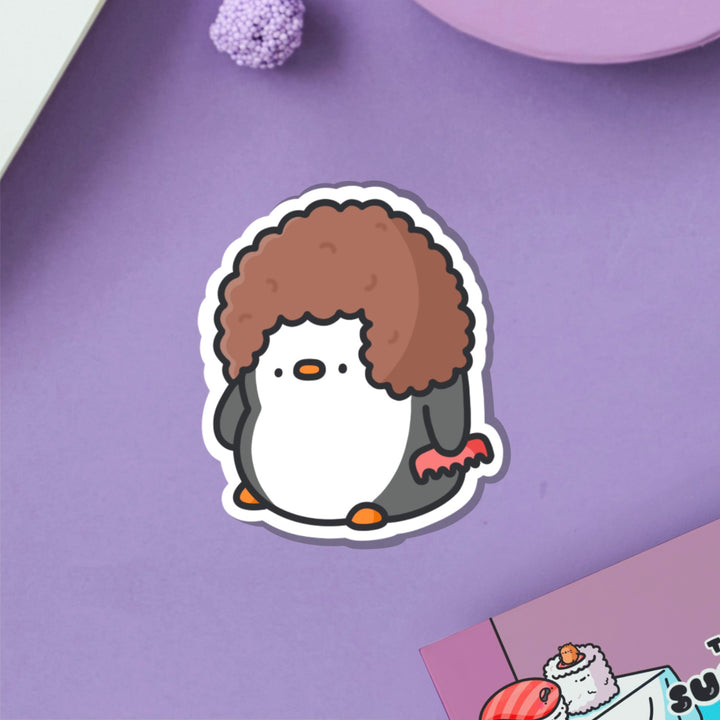 Penguin with hairdo vinyl sticker on purple table