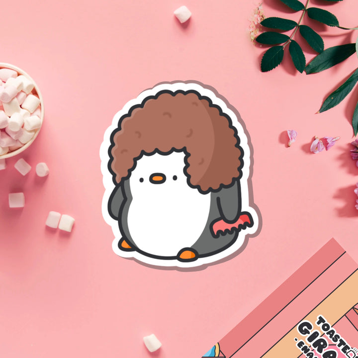 Penguin with hairdo vinyl sticker on pink table