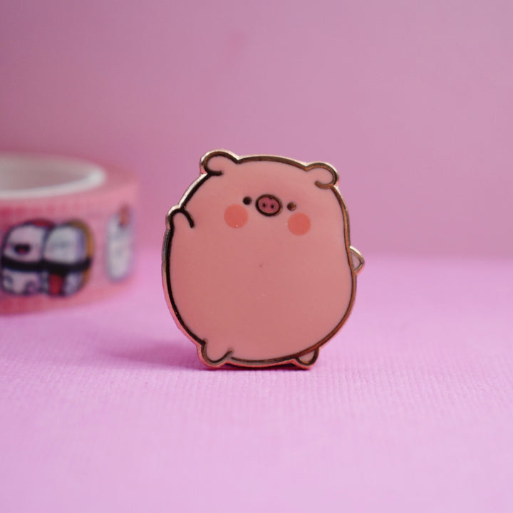 Pig enamel pin on pink table with washi tape