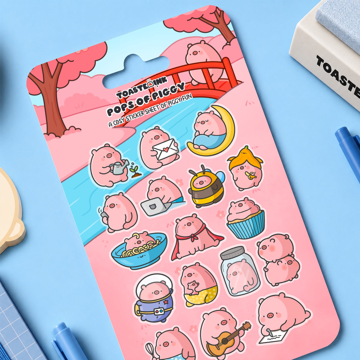 Pig sticker sheet on blue table with stationery items 