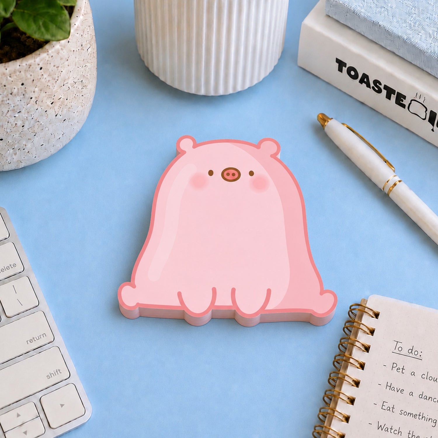 Pig shaped sticky notes on desk with notebooks