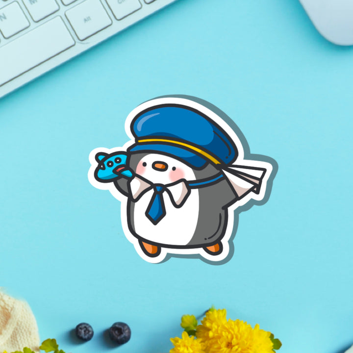 Pilot penguin vinyl sticker on blue table with keyboard