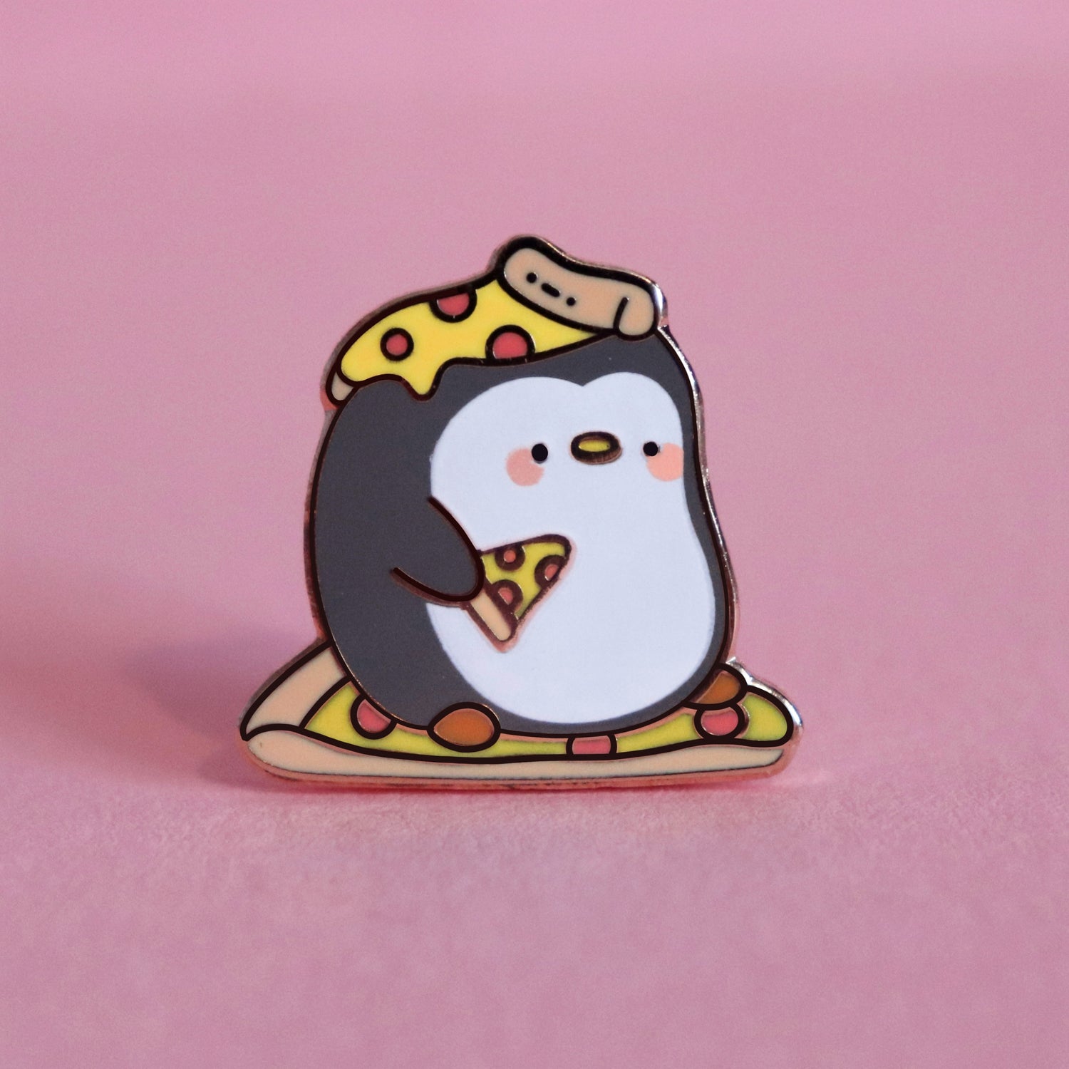 Penguin with pizza on his head enamel pin  on pink table