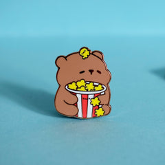 Bear with popcorn enamel pin on green desk